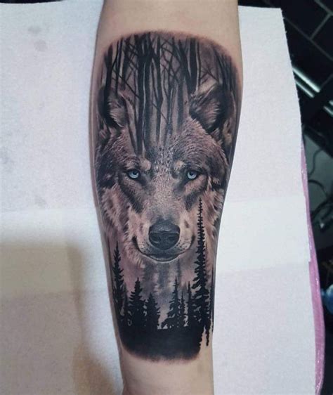 Wolf with blue eyes in a forrest black and grey forearm tattoo | Ojos ...