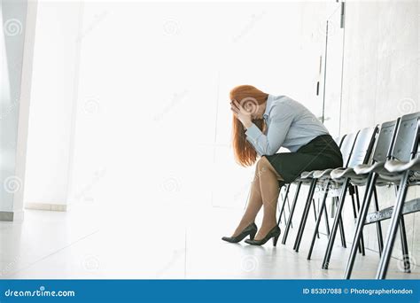 Side View Of Exhausted Businesswoman Sitting On Chair In Office Stock