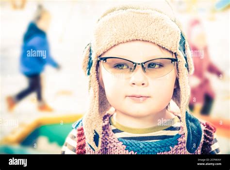 little boy portrait in hat and glasses with kids on background having ...