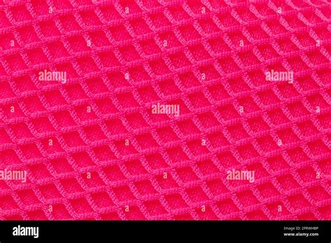 Red fabric texture. Close-up of an elastic scarlet nylon fabric with seamless pattern for sports ...