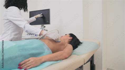 Side View Of Middle Aged Blonde Mammologist Using Ultrasound Device To