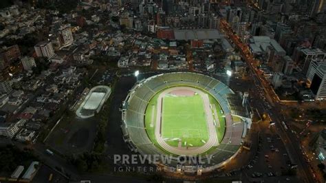 Aerial Birds Eye Shot Of Illuminated Soccer Stadium Surrounded By Quito ...