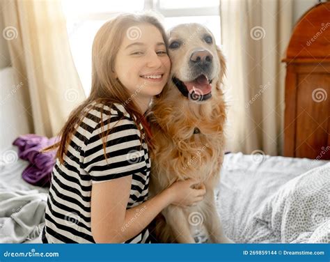 Chica Con Perro Recuperador De Oro En La Cama Foto De Archivo Imagen