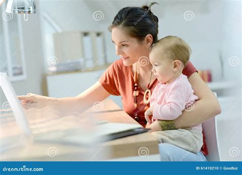 Woman Holding Her Baby And Working On Laptop Stock Photo Image Of