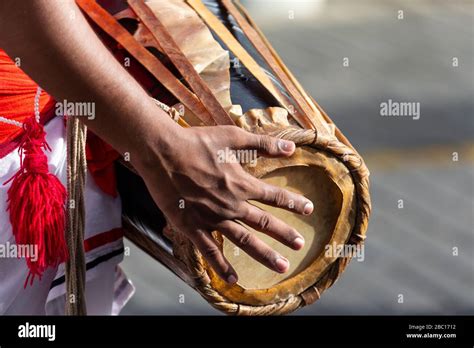 Detail of a man's hand playing a Geta Beraya drum during a Buddhist ...