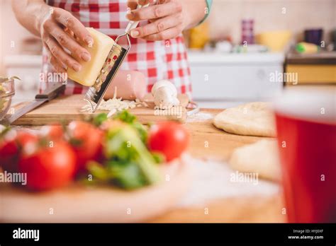 Woman Grating Cheese For Pizza In The Kitchen Stock Photo Alamy