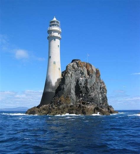 a light house sitting on top of a large rock in the middle of the ocean