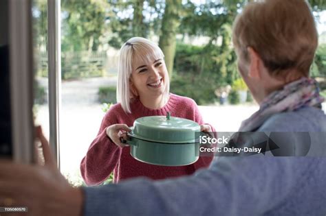 Woman Bringing Meal For Elderly Neighbour Stock Photo Download Image