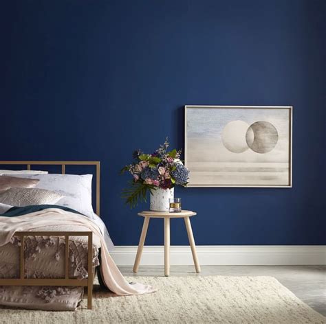 a bedroom with dark blue walls and white carpeted flooring is pictured in this image