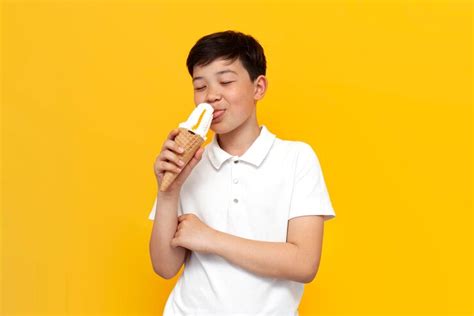 Premium Photo Asian Little Boy Of Ten Years Old Licks Ice Cream Cone