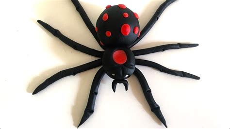 A Black Spider With Red Spots On It S Back Legs Sitting On A White Surface