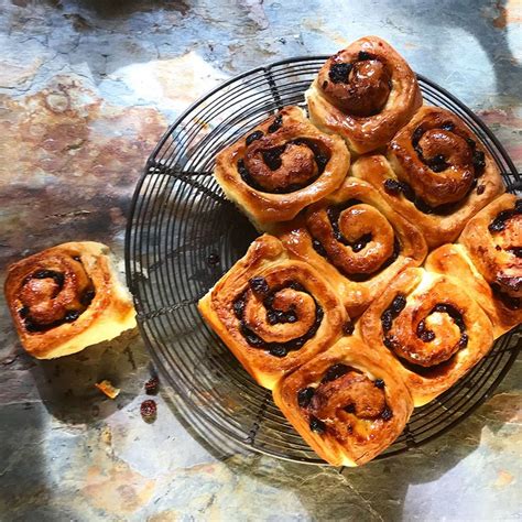 Several Cinnamon Rolls Are On A Wire Rack