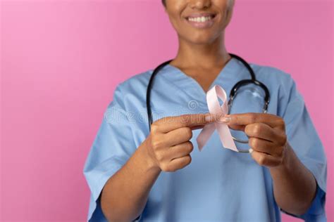 Nurse Holding Breast Cancer Awareness Pink Ribbon With Both Hands Stock