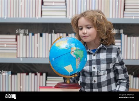 Alumno de la escuela mirando el globo en la biblioteca lección de