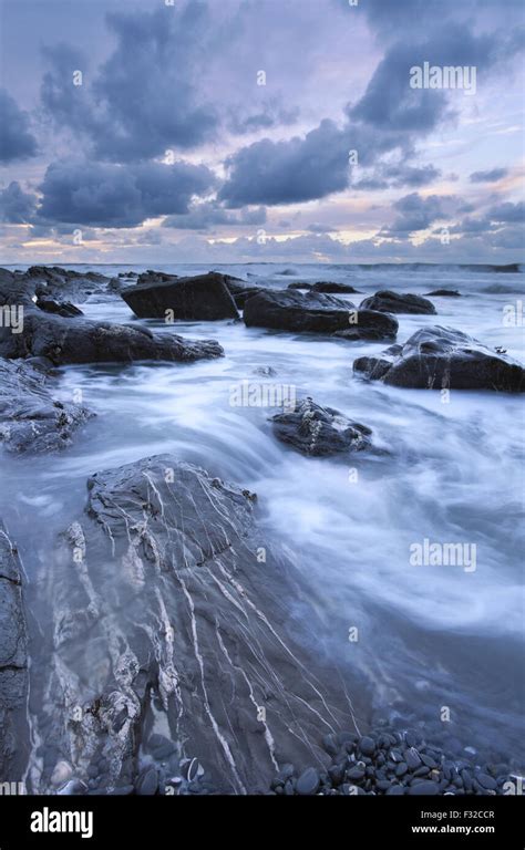 Tide Receding Down Stony Beach Revealing Large Sandstone Rocks With