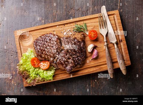 Medium Rare Grilled Beef Steak Ribeye On Cutting Board On Wooden