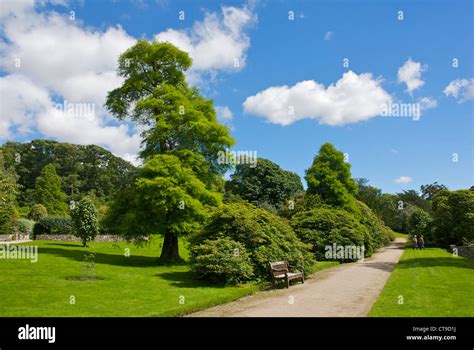 Two People Walking Through The Gardens At Holker Hall South Lakeland