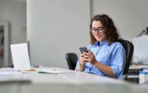 Mujer De Negocios Sonriente Joven Que Usa El Tel Fono Que Trabaja En La