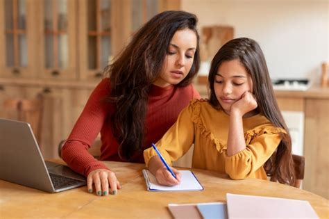 Madre E Hija Trabajando Juntas En Un Proyecto Escolar En Casa Foto