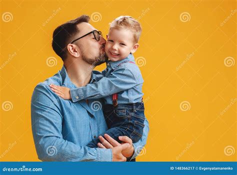 Happy Father`s Day Cute Dad And Son Hugging On Yellow Background Stock