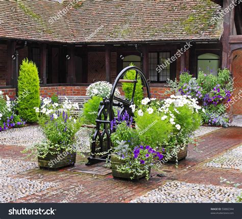 Medieval Cobbled English Courtyard Garden With Well In The Center Stock