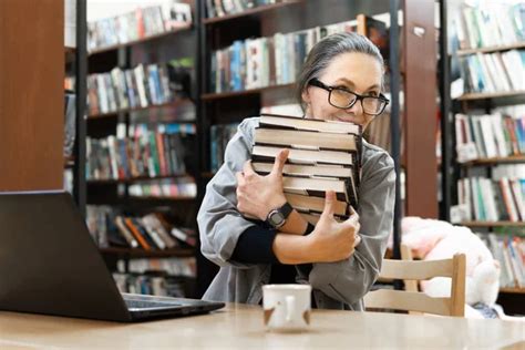 A Woman In The Library Is Busy At A Table A Middle Aged Woman With