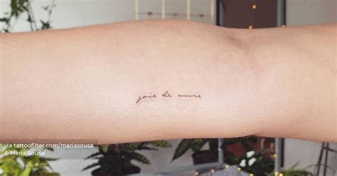 "Joie de vivre" lettering tattoo on the inner forearm.