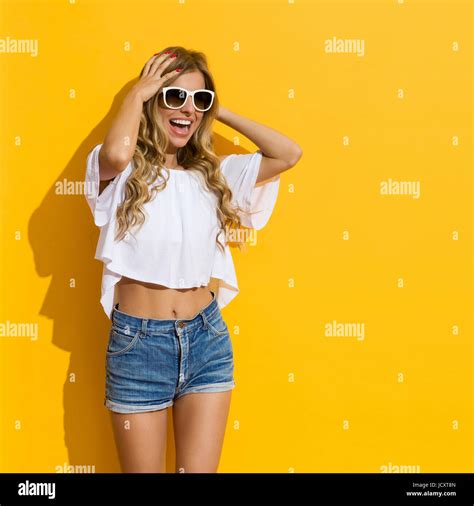 Blond Young Woman In Jeans Shorts White Shirt And White Sunglasses