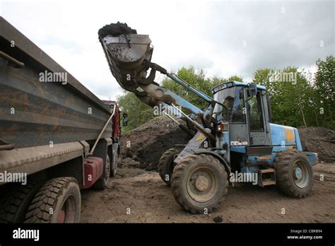 Digger Loading A Tipper Wagon Lorry With Soil Stock Photo Alamy