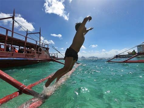 A Man Jumping Into The Water From A Boat