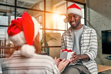 Jóvenes creativos multirraciales que llevan gorros de papá noel