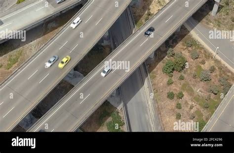 Cars Drive Down A Busy Winding Freeway Aerial Overhead Tilt Up Stock