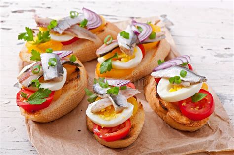 Crostini Con Las Anchoas Los Tomates Y El Huevo Imagen De Archivo