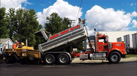 Kenworth T800h Dump Truck Hauling And Dumping Asphalt Into Cat Paver