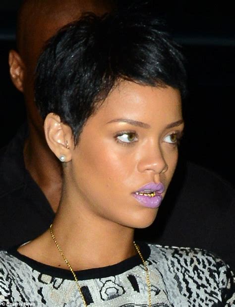 Reflective Rihanna wears a set of grills over her teeth as she enjoys ...