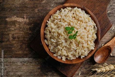 Bowl of cooked Whole grain brown rice on wooden background overhead ...