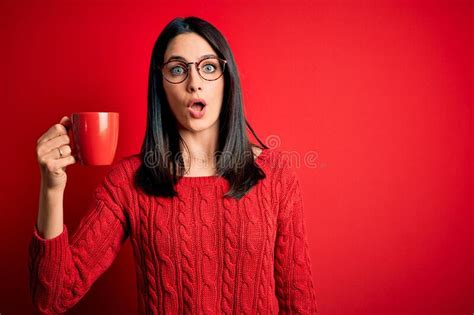 Young Brunette Woman With Blue Eyes Wearing Glasses And Drinking A Cup