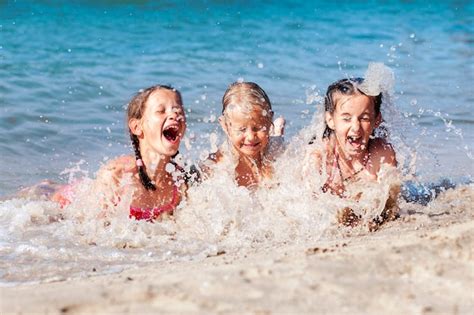 Niños Felices Divirtiéndose Jugando Con Las Olas Del Mar En La Playa De