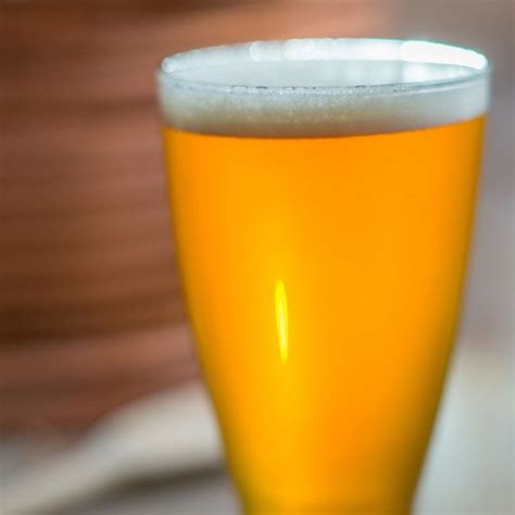 A Glass Of Beer Sitting On Top Of A Table