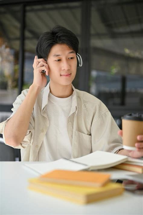 Portrait Of Happy Asian Man Listening To Music Through Headphones While