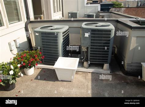 Air Conditioner Units On The Roof Deck In The Sun With Plants Stock