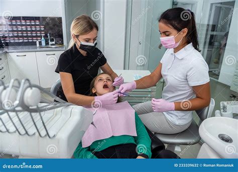 Dentist Examines The Oral Cavity Of Patient In Clinic Stock Photo