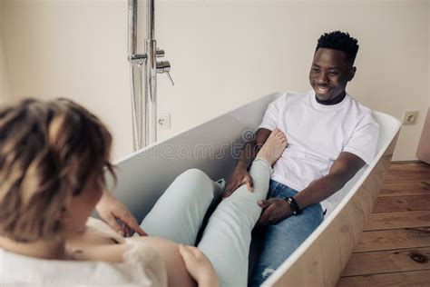 Young Happy African Man And Caucasian Pregnant Woman Take A Bath Stock