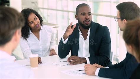 African Businessman Talking Handshaking Colleague At Group Meeting