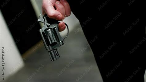 Close Up Guy Lowers His Hand With Revolver Pistol To His Leg In Black