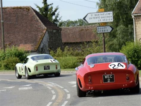 Two Cars Are Driving Down The Road In Front Of Each Other One Is Red