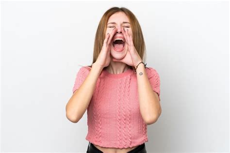 Joven Inglesa Aislada De Fondo Blanco Gritando Y Anunciando Algo Foto