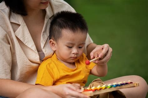 Vue De Face Mère Et Enfant Assis Sur L herbe Photo Gratuite