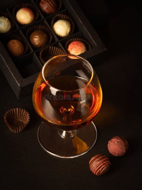 Un Vidrio De Brandy Y De Chocolates En Una Caja De Papel Bebida