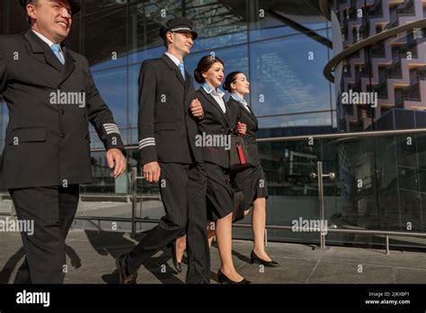 Two Young Flight Attendants Walking With Pilots Outdoor Stock Photo Alamy